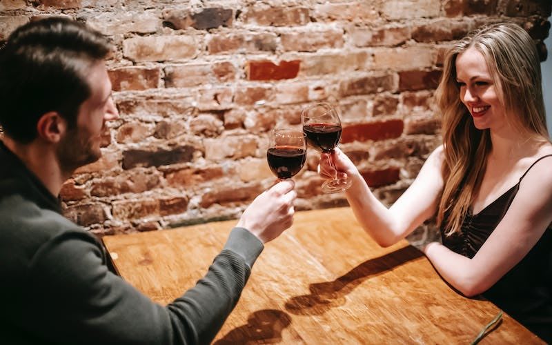 Para przy stole pijąca wino
